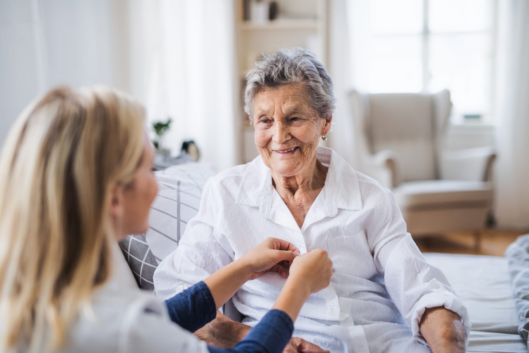 Pflegefachkraft hilft im ambulanten Pflegedienst Seniorin im Eigenheim